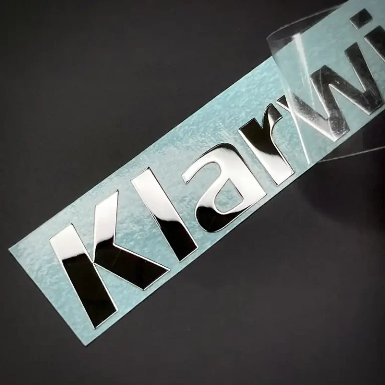 custom metal logo sticker applied to electronic device surface