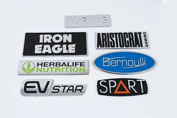 Custom metal logo plates mounted on product housings and branded equipment - Himgo